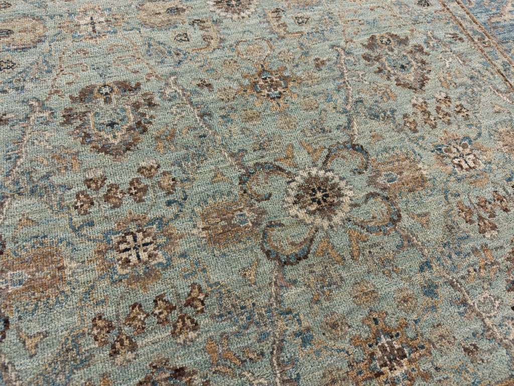 Traditional wool area rug with cyan, brown and ivory.