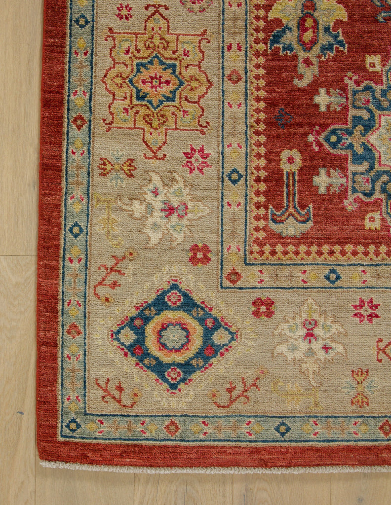 6x9 beige border rug with navy blue, bright red, dirty gold and coral accents.