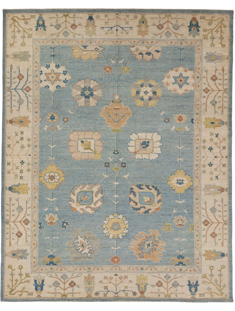 Roya Rugs hand knotted light blue Oushak rug for sale 9x12 with colorful muted floral design.