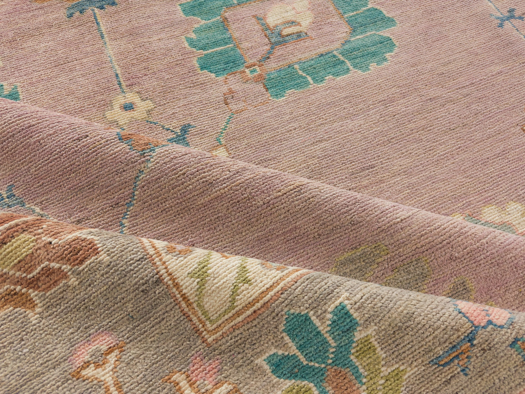 Hand knotted modern oushak rug in lilac, warm grey, pink, lavender, green and turquoise.