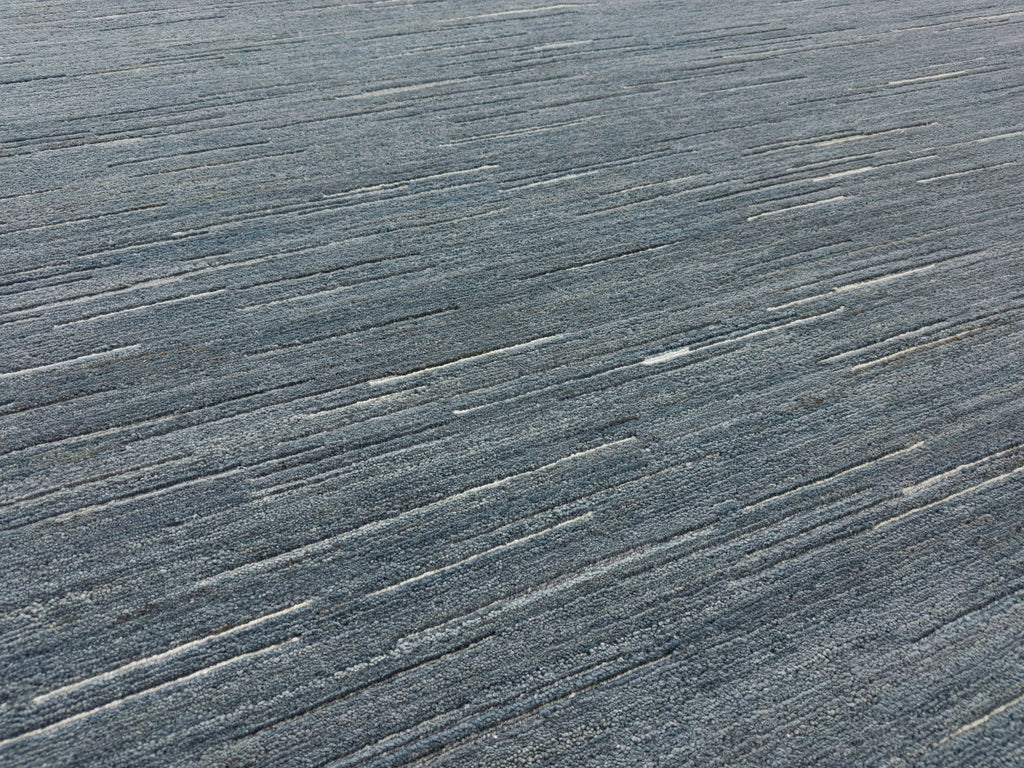 Linear wool rug solid denim wool in coarse dense pile with texture pile and hand knotted with Tibetan weave.