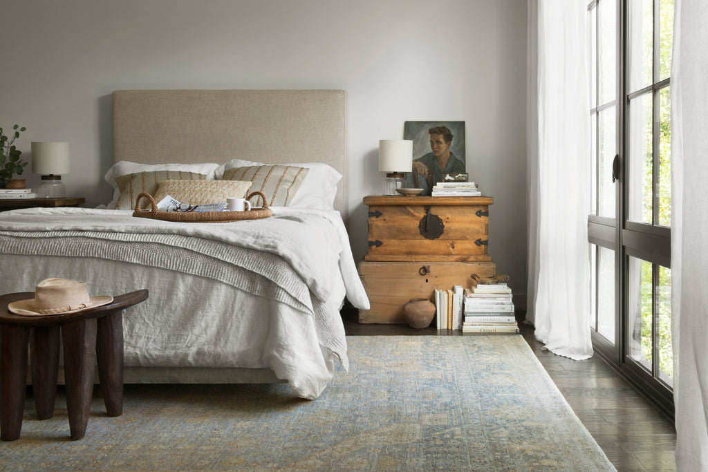 Casual bedroom with a light blue distressed Oushak area rug.