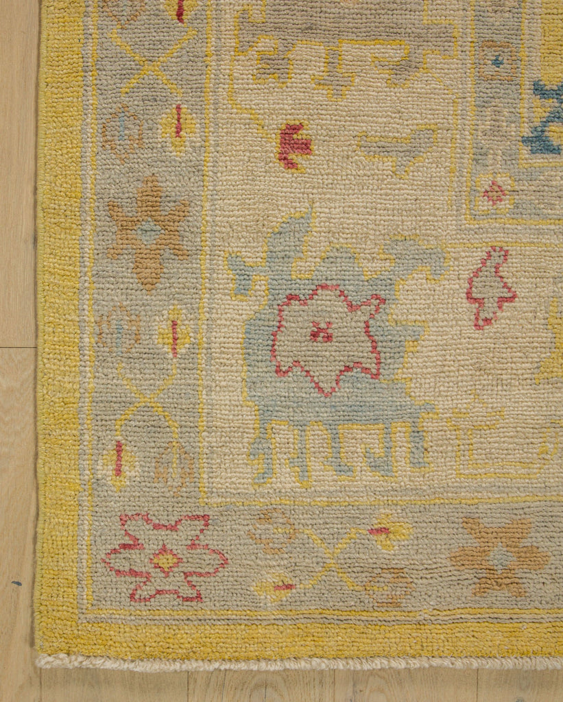 Bright yellow wool rug with sky blue, light grey, coral red, brown and oriental Oushak design.
