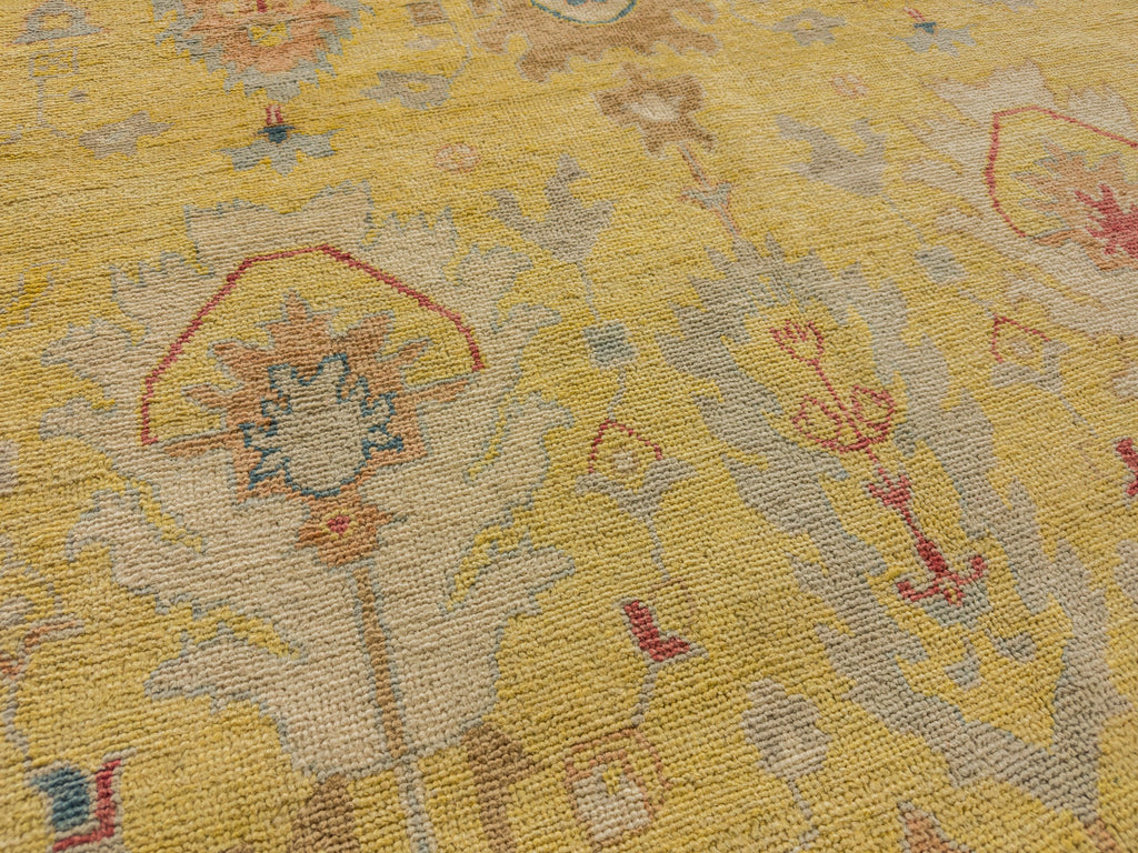 Hand knotted yellow oriental rug with neutral beige, clay, coral red, blue grey and teal accents.