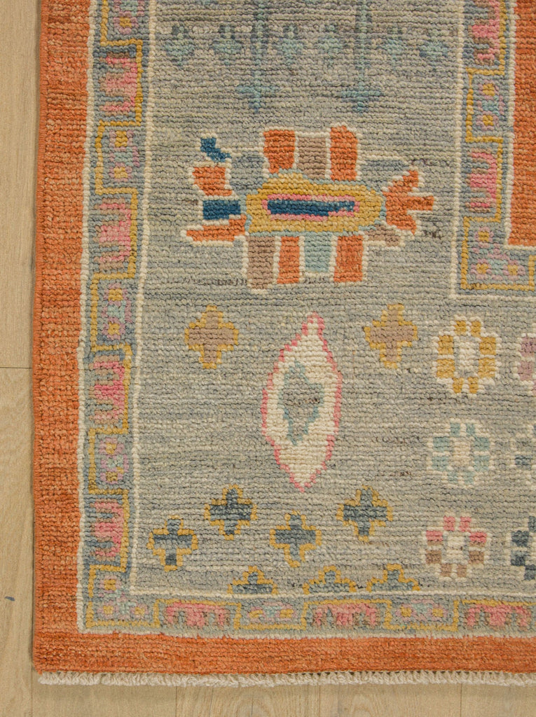 8x10 orange and blue oriental rug made of wool and spa, mist, gold, pink and ivory white accents.