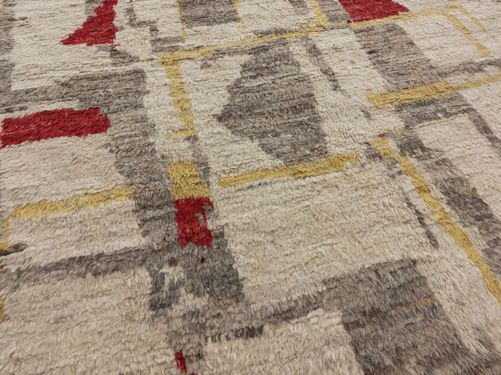 Hand knotted modern Moroccan rug with a wool shag pile and red, gold, grey, ivory and earth tone colors.