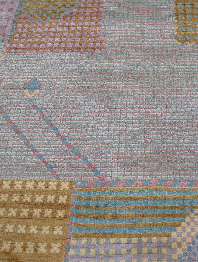 carved high low texture square block design hand knotted rug with pink, gold, lavender, blue and sea foam colors.