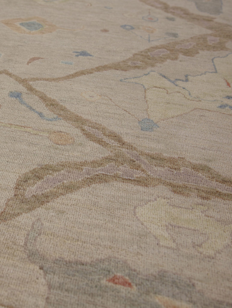 Antique looking tan, coral, lavender purple, yellow and blue traditional wool rug with round circles.