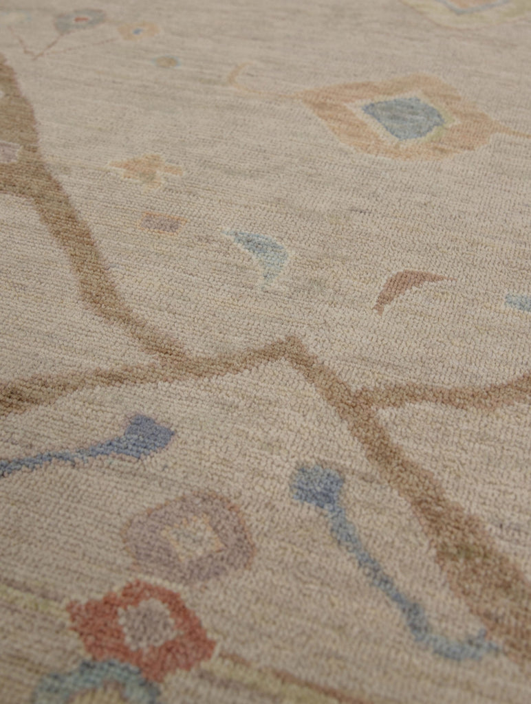 Antique looking tan, coral, lavender purple, yellow and blue traditional wool rug with round circles.