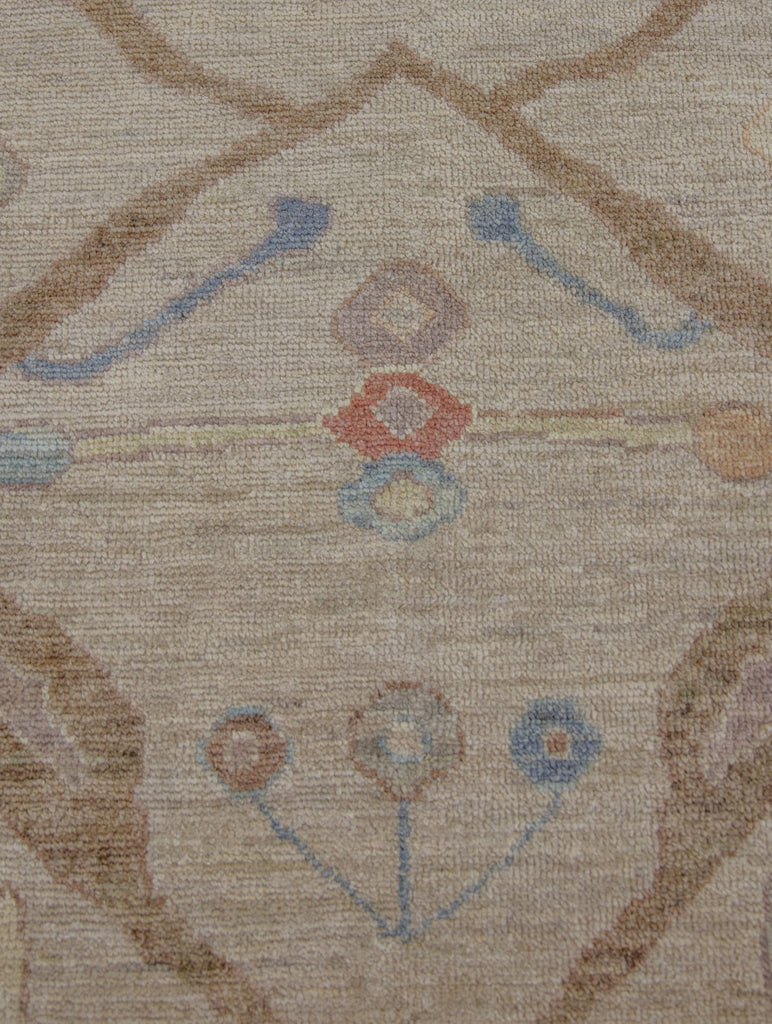 Antique looking tan, coral, lavender purple, yellow and blue traditional wool rug with round circles.