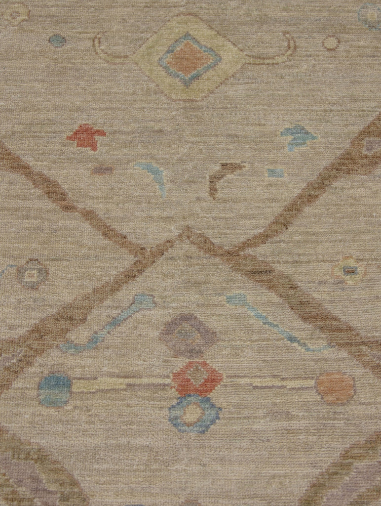 Antique looking tan, coral, lavender purple, yellow and blue traditional wool rug with round circles.