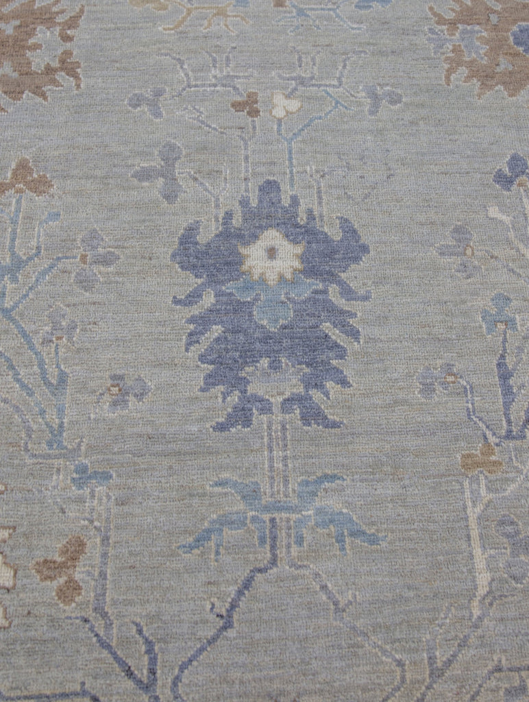 8x10 hand knotted modern oriental Oushak rug made of wool with grey green tint primary colors and accent dark blue, brown and ivory/beige.
