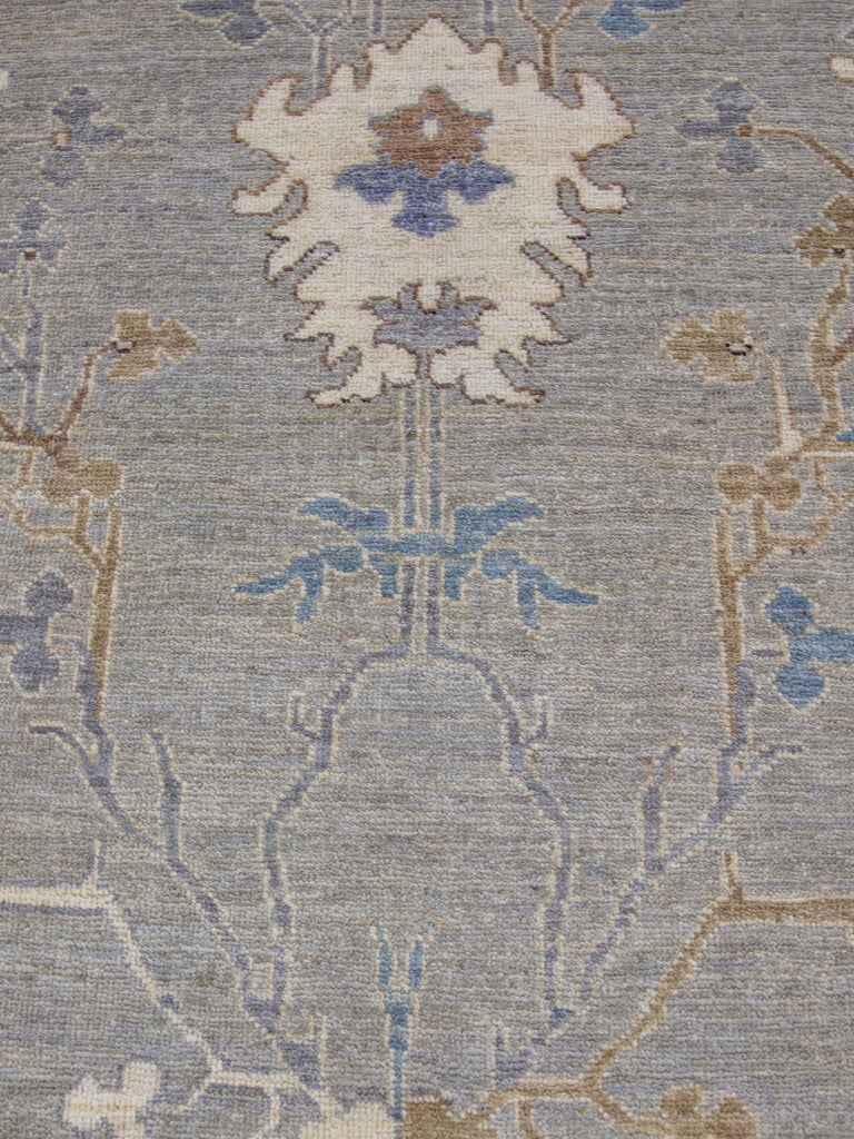 8x10 hand knotted modern oriental Oushak rug made of wool with grey green tint primary colors and accent dark blue, brown and ivory/beige.