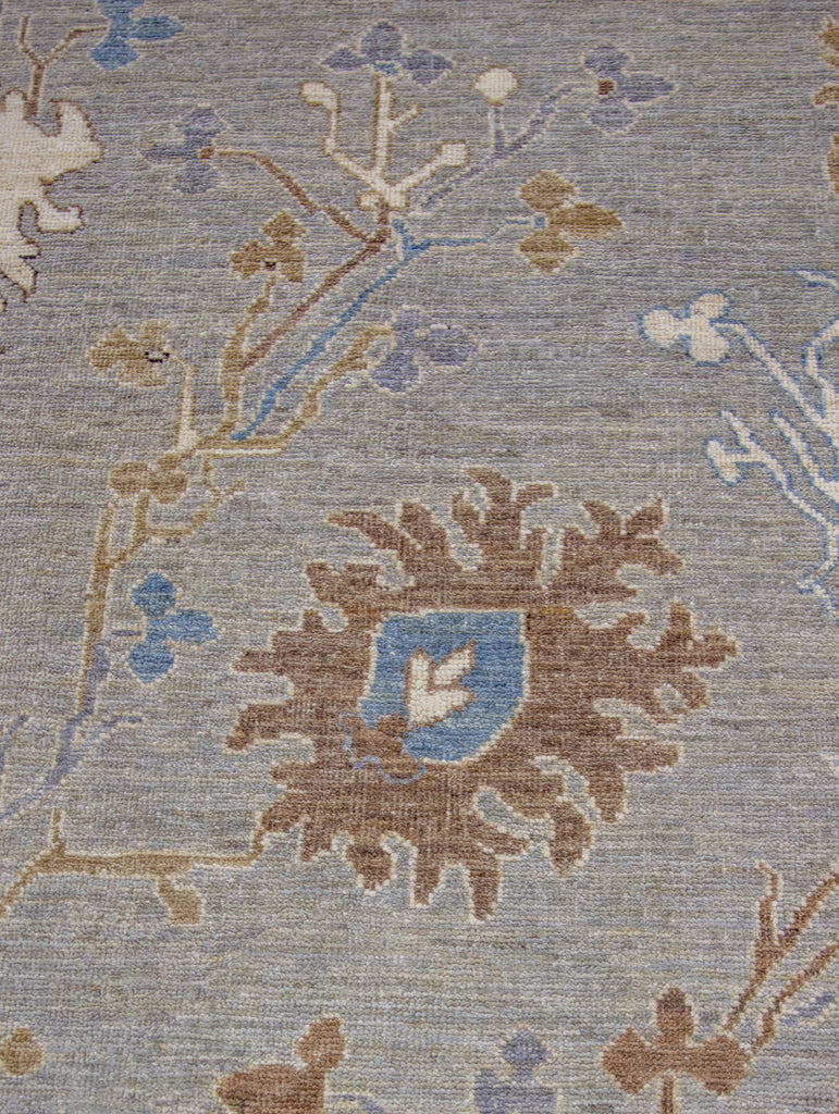 8x10 hand knotted modern oriental Oushak rug made of wool with grey green tint primary colors and accent dark blue, brown and ivory/beige.