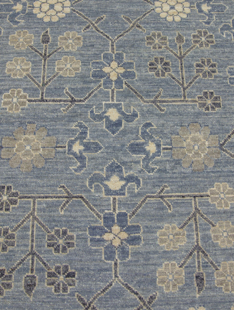 9x12 size, new hand knotted floral and geometric oushak wool area rug with blues, charcoal grey/black, ivory, taupe and beige.