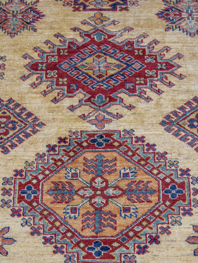 9' x 12' oriental wool rug with geometric southwest design in ivory and red primary color and accent jade green, yellow/gold, navy blue, and light blue accents.