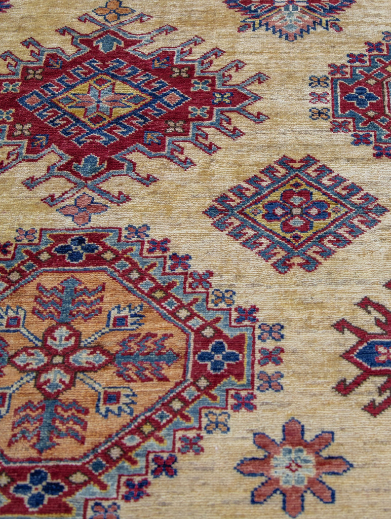 9' x 12' oriental wool rug with geometric southwest design in ivory and red primary color and accent jade green, yellow/gold, navy blue, and light blue accents.