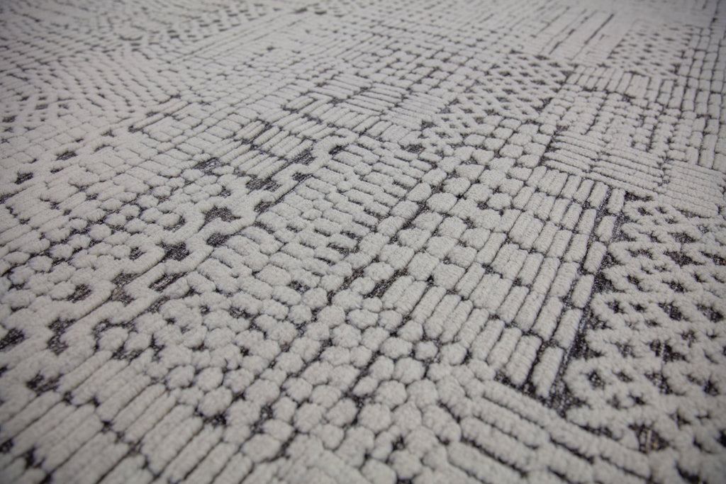 Hand Knotted of wool on a cotton foundation the sahara collection offers a tribal rug with texture, depth and sustainable rug. Colors are ivory white black dark brown and organic. sizes available in 6x9 8x10 9x12 10x14 12x15. performance and durable luxury roya rug.
