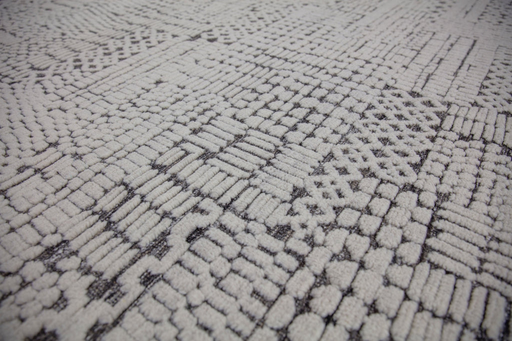 Hand Knotted of wool on a cotton foundation the sahara collection offers a tribal rug with texture, depth and sustainable rug. Colors are ivory white black dark brown and organic. sizes available in 6x9 8x10 9x12 10x14 12x15. performance and durable luxury roya rug.