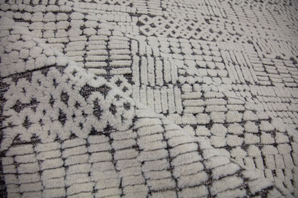 Hand Knotted of wool on a cotton foundation the sahara collection offers a tribal rug with texture, depth and sustainable rug. Colors are ivory white black dark brown and organic. sizes available in 6x9 8x10 9x12 10x14 12x15. performance and durable luxury roya rug.