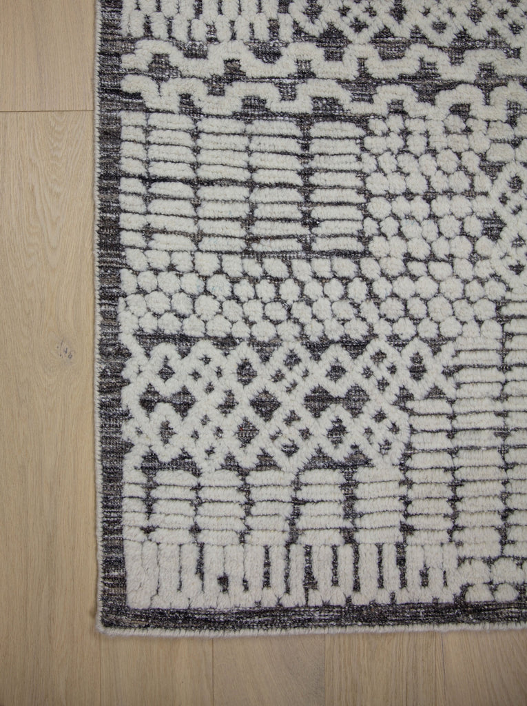 Hand Knotted of wool on a cotton foundation the sahara collection offers a tribal rug with texture, depth and sustainable rug. Colors are ivory white black dark brown and organic. sizes available in 6x9 8x10 9x12 10x14 12x15. performance and durable luxury roya rug.