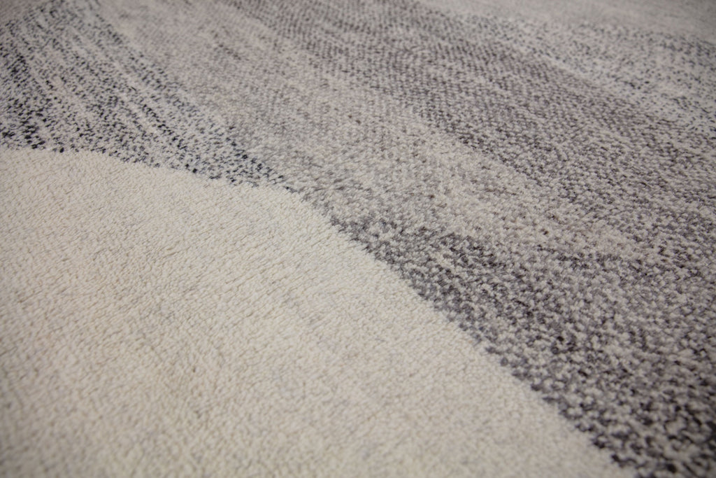 Hand Knotted wool and viscose rug with a soft pile and geometric design inspired by the African landscape. Bohemian look with ivory, gray, brown and black colors.  
