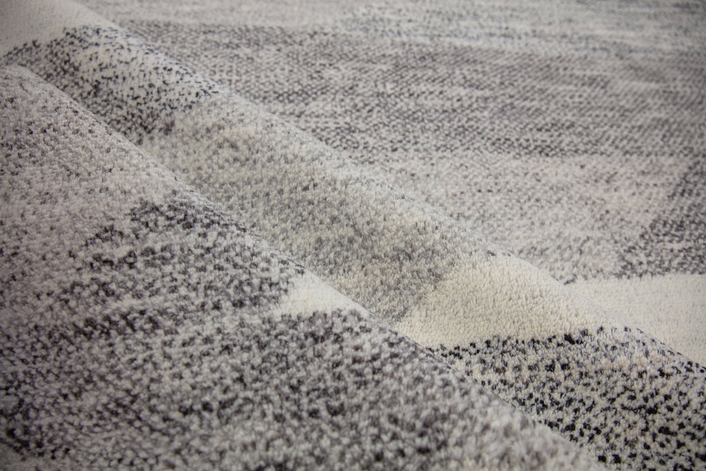 Hand Knotted wool and viscose rug with a soft pile and geometric design inspired by the African landscape. Bohemian look with ivory, gray, brown and black colors.  