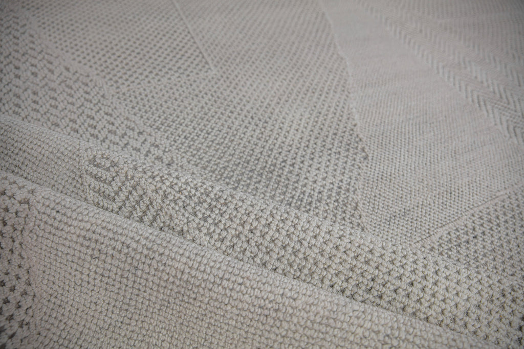 handcrafted Claire CL-02 Ivory color by Roya Rugs. 3D textured, hand-carved and wool rug. Neutral Ivory/White color with hints of gray. Geometric pattern, but solid rug from a distance. Contemporary Modern wool and cotton rug available in sizes of 18x18 samples, 2x3, 6x9, 8x10, 9x12, 10x14 and oversized 12x15