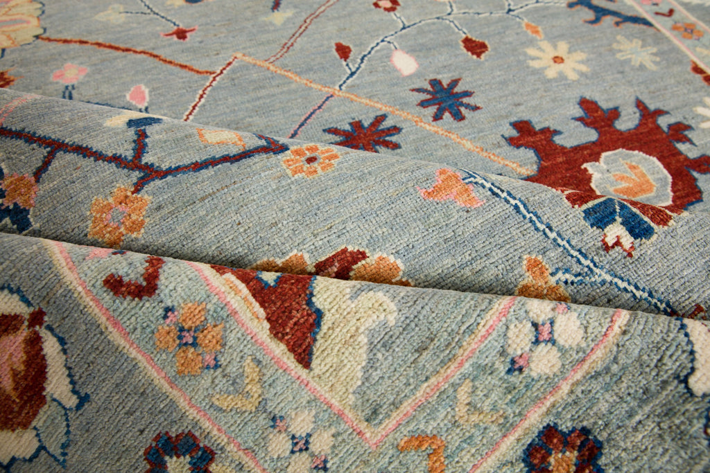 Roya Rugs fine oriental vibrant powder blue and pink floral oushak rug with accent red, navy blue, ivory, orange and celadon green accents. Charlotte nc rugs.