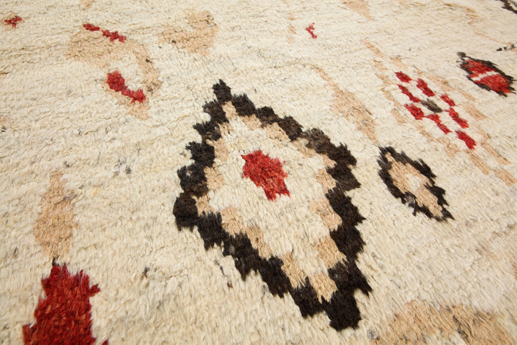 7x10 hand knotted luxury geometric wool rug with tan, neutral earth tones, and red colors perfect for cabin, ranch and mountain homes with bulls. Soft Bohemian style Moroccan berber rug from Roya Rugs in Hickory North Carolina.