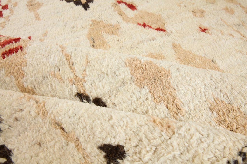 7x10 hand knotted luxury geometric wool rug with tan, neutral earth tones, and red colors perfect for cabin, ranch and mountain homes with bulls. Soft Bohemian style Moroccan berber rug from Roya Rugs in Hickory North Carolina.