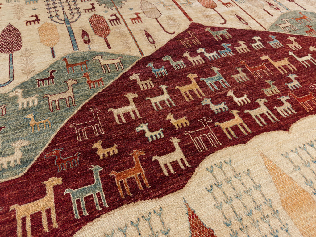 Roya Rugs Hickory North Carolina 9x12 handmade modern red tribal wool rug with ivory, green, beige, light blue and orange with animals, goats, sheep, and mountain hills.