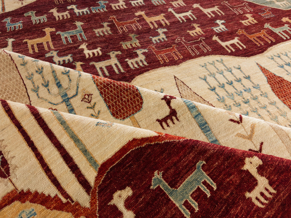 Roya Rugs Hickory North Carolina 9x12 handmade modern red tribal wool rug with ivory, green, beige, light blue and orange with animals, goats, sheep, and mountain hills.