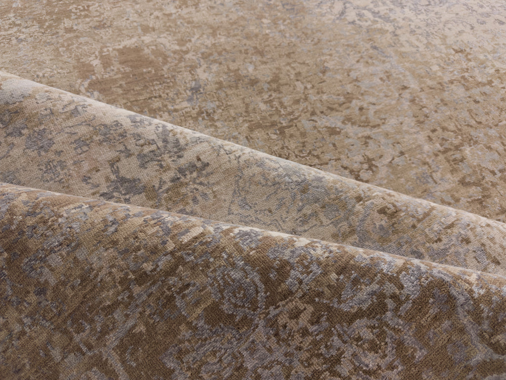 Folded distressed rug with taupe silver and beige.
