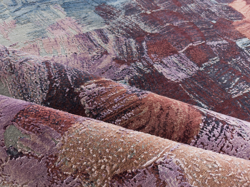 Folded abstract silk rug with dark red, clay, apricot and purple.