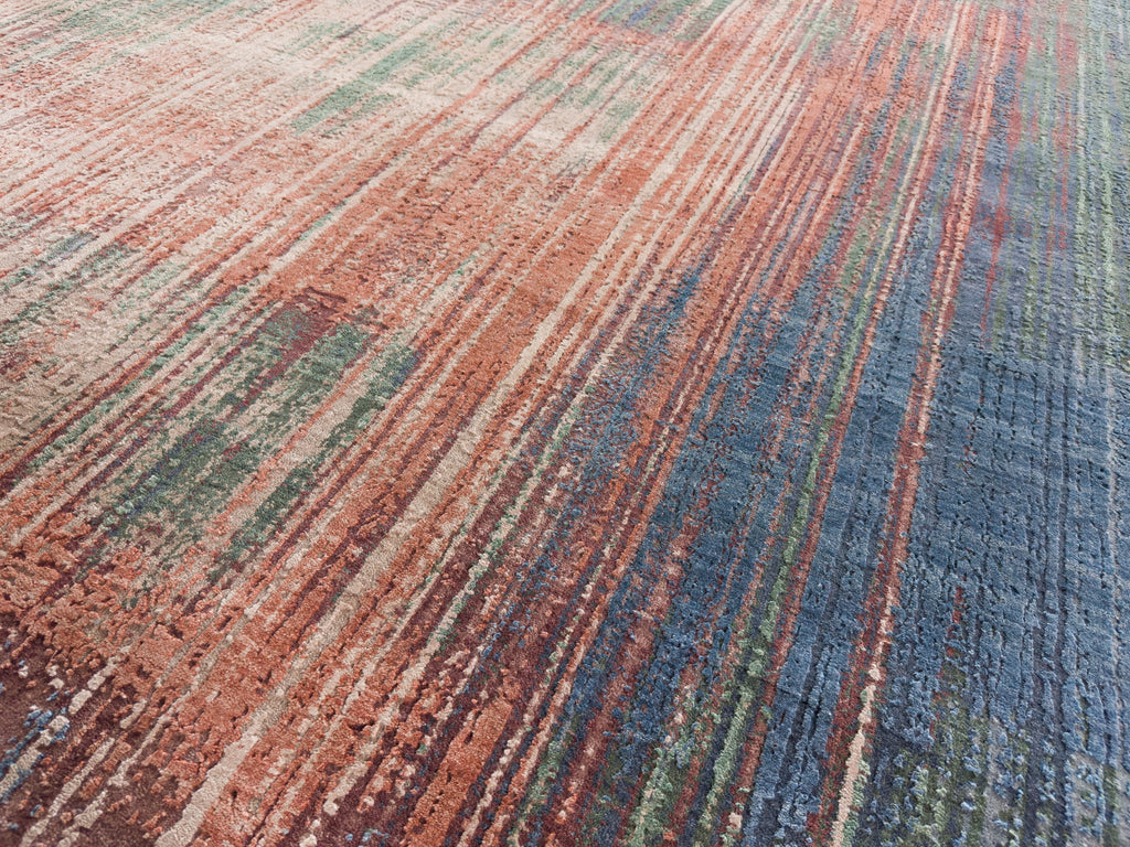 Colorful linear design rug with silk accents and blue, burgundy red, and clay orange.